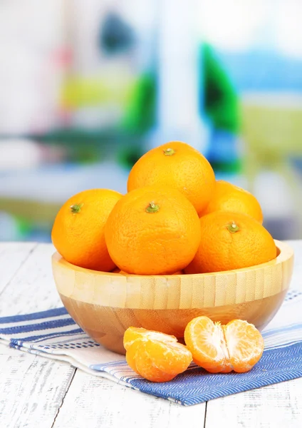 Ripe sweet tangerines with spices in bowl, on napkin, on bright background — Stock Photo, Image