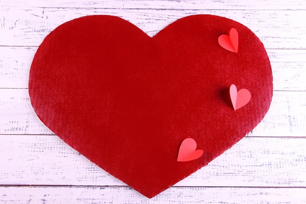 Big red heart with small hears on wooden background — Stock Photo, Image