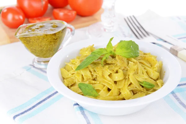 Läckra pasta med pesto på tallriken på bordet närbild — Stockfoto