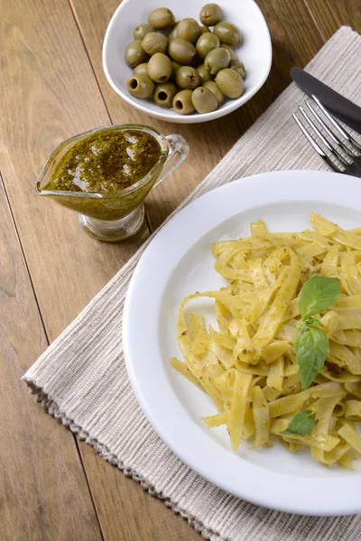 Massa deliciosa com pesto no prato na mesa close-up — Fotografia de Stock