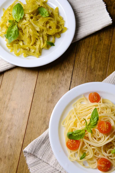 Utsökt spaghetti med tomater på tallriken på bordet närbild — Stockfoto