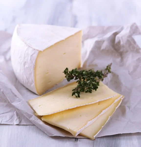 Sabroso queso Camembert con tomillo, sobre mesa de madera —  Fotos de Stock