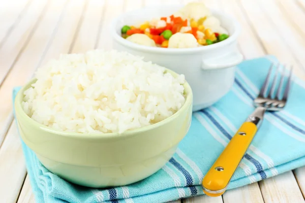 Kokt ris med grönsaker på träbord närbild — Stockfoto