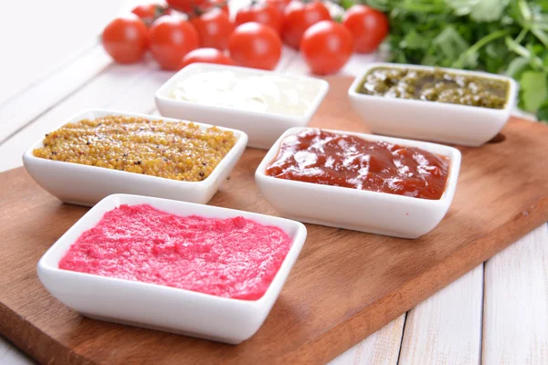 Varias salsas en la tabla de cortar en primer plano de la mesa — Foto de Stock