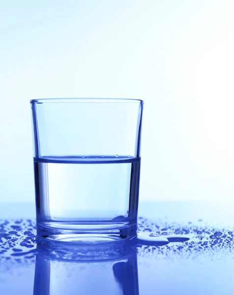 Wasser im Glas, auf blauem Hintergrund — Stockfoto