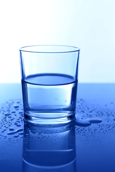 Wasser im Glas, auf blauem Hintergrund — Stockfoto