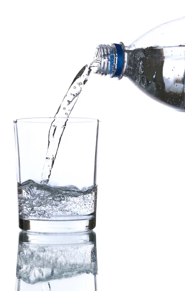 Verser l'eau de la bouteille dans du verre, sur fond bleu clair — Photo