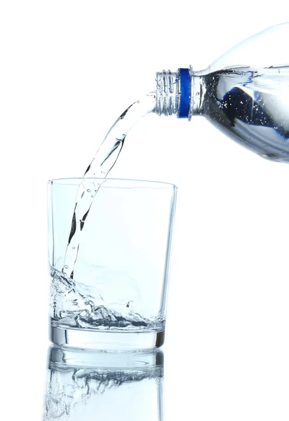 Pour water from bottle into glass, on light blue background — Stock Photo, Image