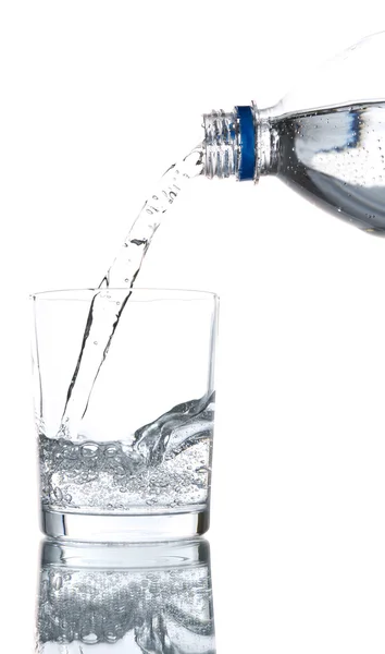 Nalijte vodu z láhve do skla, na světle modrém pozadí — Stock fotografie