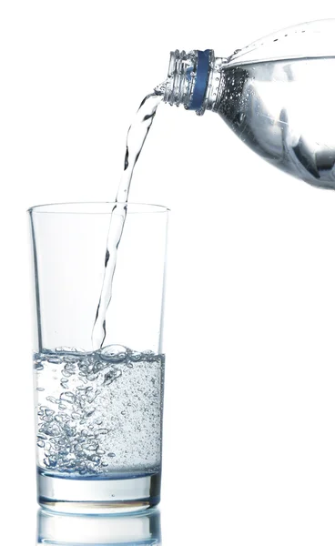 Ρίχνουμε νερό από το μπουκάλι στο ποτήρι, απομονωμένα σε λευκό — Φωτογραφία Αρχείου