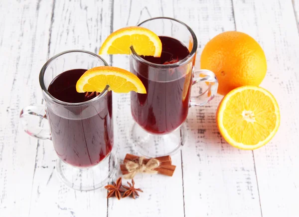 Mulled wine with oranges and spices on wooden background — Stock Photo, Image