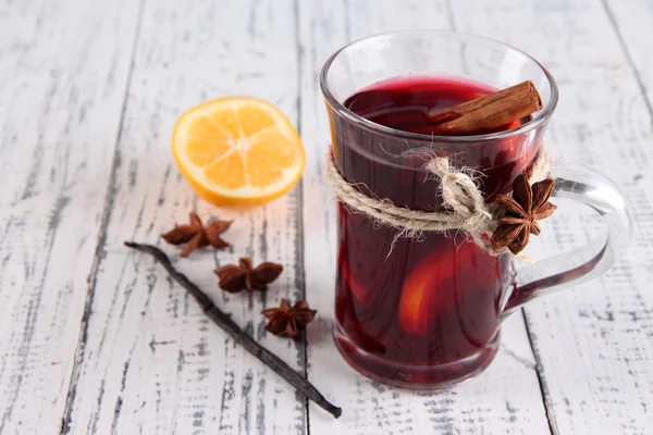 Vino rimuginato con limone e spezie su fondo di legno — Foto Stock