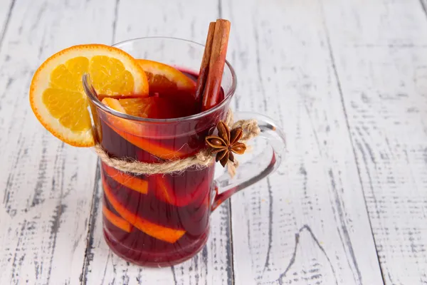 Glühwein met sinaasappel en specerijen op houten achtergrond — Stockfoto