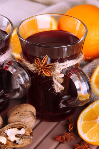 Вино с апельсинами и орехами на столе — стоковое фото