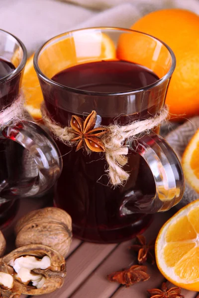 Vino caliente con naranjas y nueces en la mesa de cerca —  Fotos de Stock