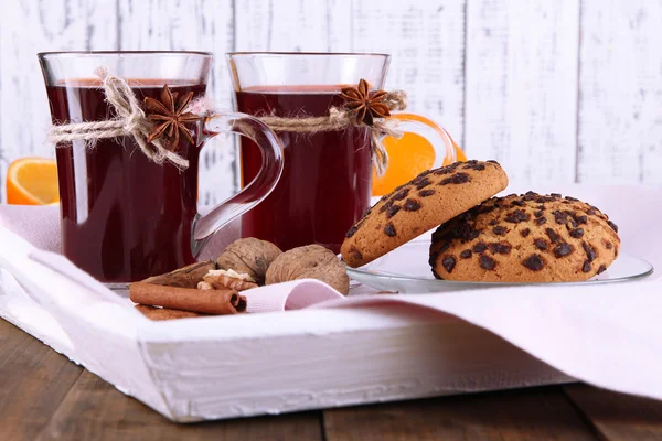 Mulled wine with oranges and cookies on table on wooden background — Stock Photo, Image