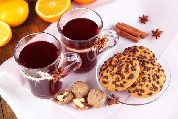 Вино с апельсинами и печеньем на столе — стоковое фото