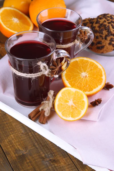 Glühwein met sinaasappels en cookies op tafel close-up — Stockfoto