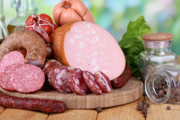 Different sausages on wooden table on natural background — Stock Photo, Image