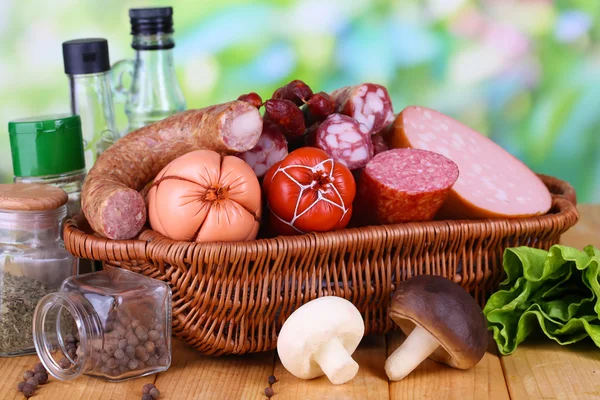 Different sausages on wooden table on natural background — Stock Photo, Image