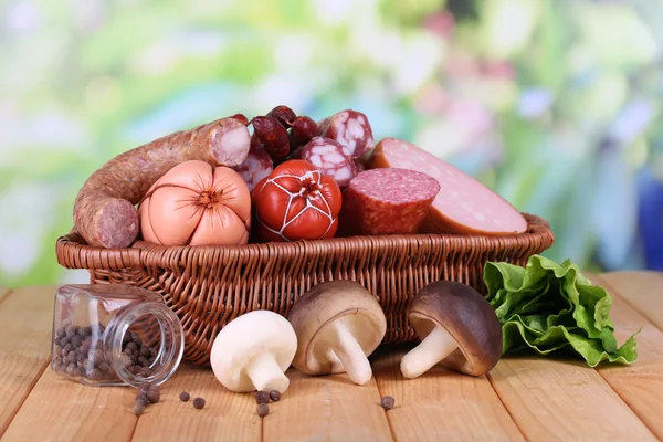 Different sausages on wooden table on natural background — Stock Photo, Image