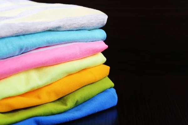 Pilha de roupas coloridas, isoladas em preto — Fotografia de Stock