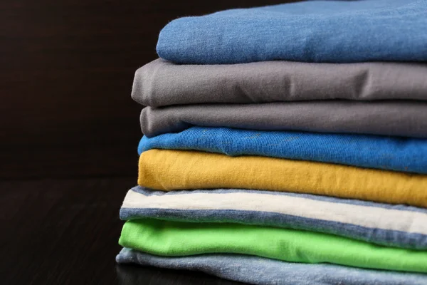 Stack of colorful clothes, isolated on black — Stock Photo, Image