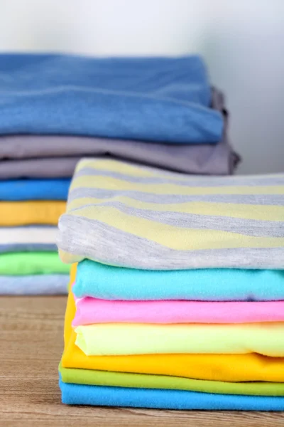 Empilement de vêtements colorés, sur fond clair — Photo