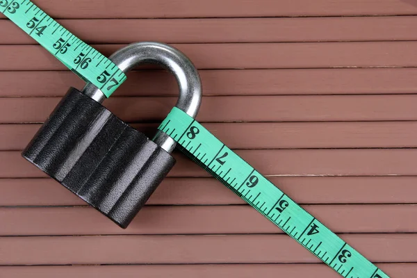 Conceptual photo of unlocking secret of weight loss. On color wooden background — Stock Photo, Image