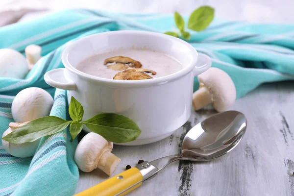 Mushroom soup in white pot, on napkin, on wooden background — Stock Photo, Image