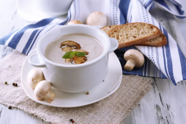 Minestra di funghi in pentole bianche, su tovagliolo, su sfondo di legno — Foto Stock