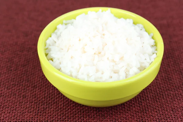 Cooked rice in bowl on red background — Stock Photo, Image
