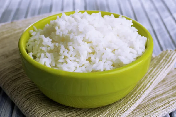 Cooked rice in bowl on wooden background — Stock Photo, Image