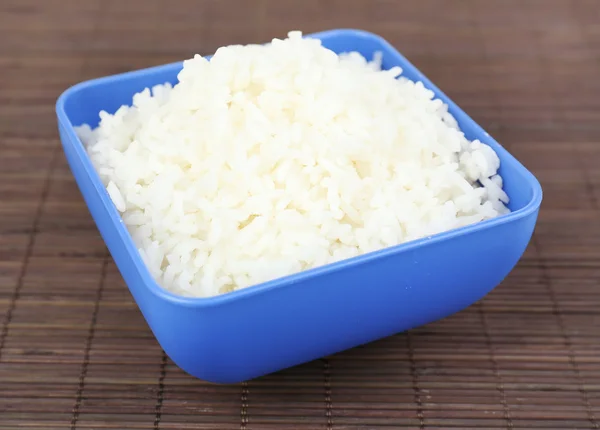 Варёный рис в миске на бамбуковом фоне — стоковое фото