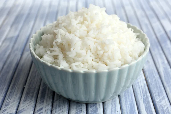 Arroz cocido en tazón sobre fondo de madera — Foto de Stock