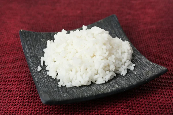 Cooked rice on red background — Stock Photo, Image