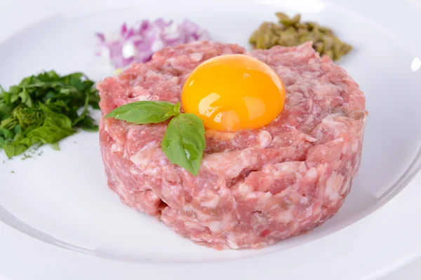 Delicioso bife tartare com gema de ovo na placa close-up — Fotografia de Stock