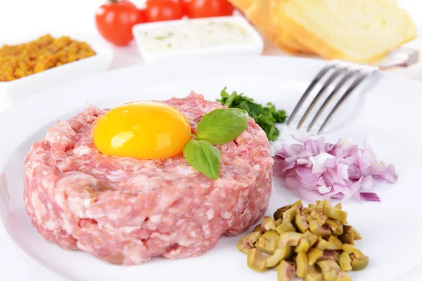 Delicioso bife tartare com gema de ovo na placa na mesa close-up — Fotografia de Stock