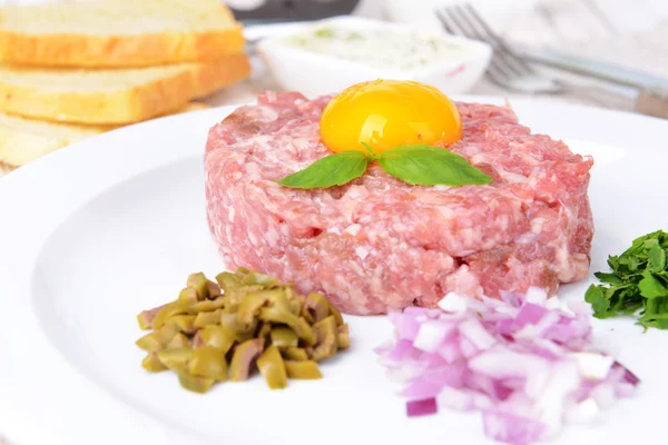 Delicious steak tartare with yolk on plate on table close-up — ストック写真