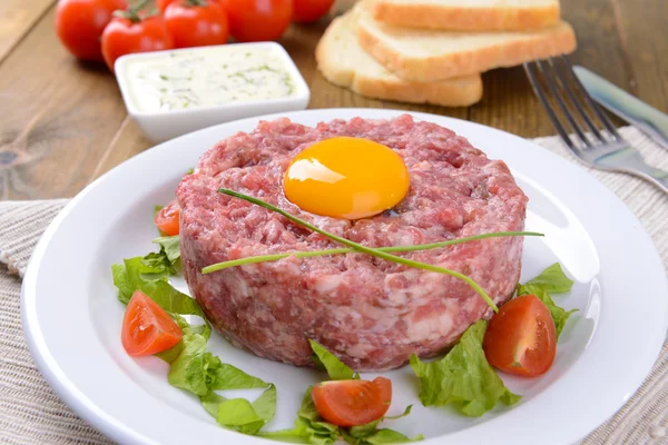 Délicieux tartare de steak avec jaune sur plaque sur table close-up — Photo