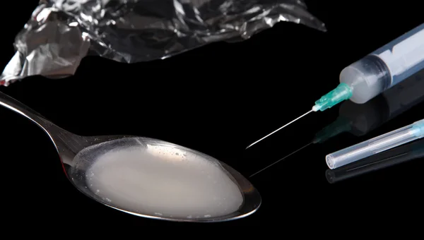 Heroin in spoon on black background — Stock Photo, Image