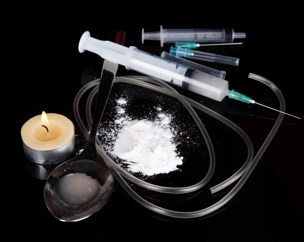 Heroin in spoon and syringe on black background — Stock Photo, Image