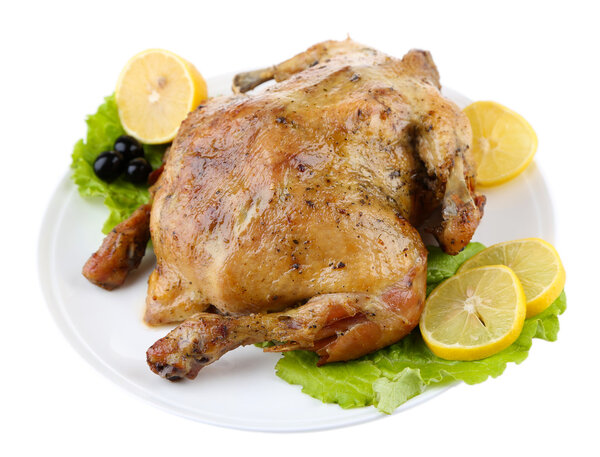 Whole roasted chicken with vegetables on plate, isolated on white