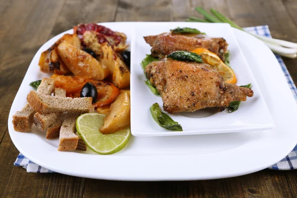 Palitos de pollo fritos hechos en casa con verduras en plato, sobre fondo de madera — Foto de Stock