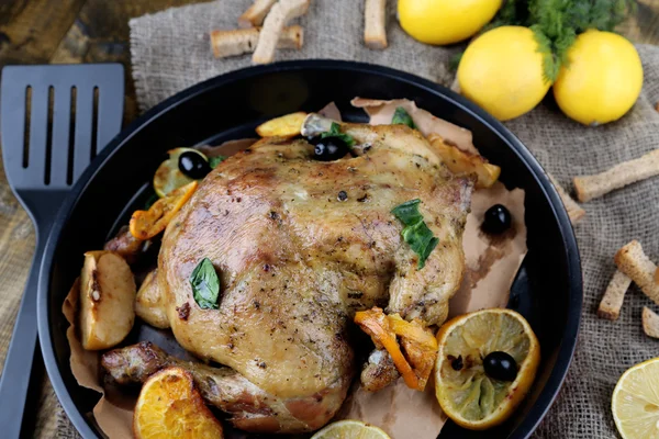 Whole roasted chicken with vegetables on pan, on wooden background — Stock Photo, Image