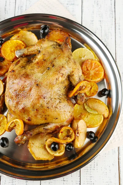 Geheel gebraden kip met groenten op dienblad, op houten achtergrond — Stockfoto