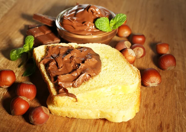 甘いチョコレートのヘーゼル ナッツ スプレッド木製の背景を持つパンします。 — ストック写真