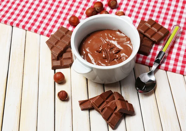 Słodka czekolada z orzechami laskowymi z całych orzechów i mięty na drewniane tła — Zdjęcie stockowe