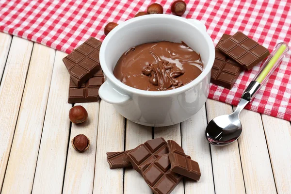 Sweet chocolate hazelnut spread with whole nuts and mint on wooden background — Stock Photo, Image