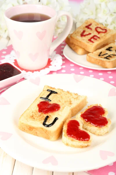 Delicioso brindis con mermelada y taza de té en primer plano de la mesa — Foto de Stock